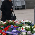 Older Woman Inspecting Wreaths by Cenotaph
