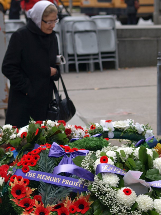 Older Woman Inspecting Wreaths by Cenotaph